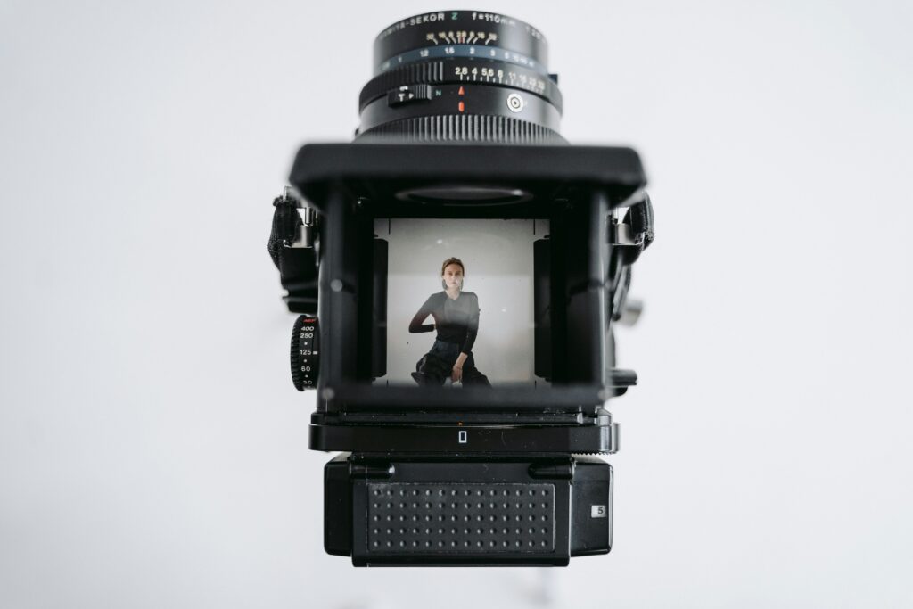 A vintage camera focuses on a person for a professional photoshoot with a classic touch.